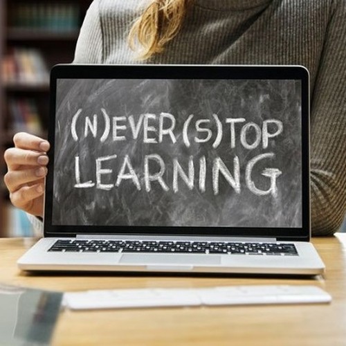Titelbild des Fort- und Weiterbildungsprogramms aus dem Jahr 2023. Gezeigt wird ein Monitor mit der Beschriftung: (N)ever (S)top Learning.