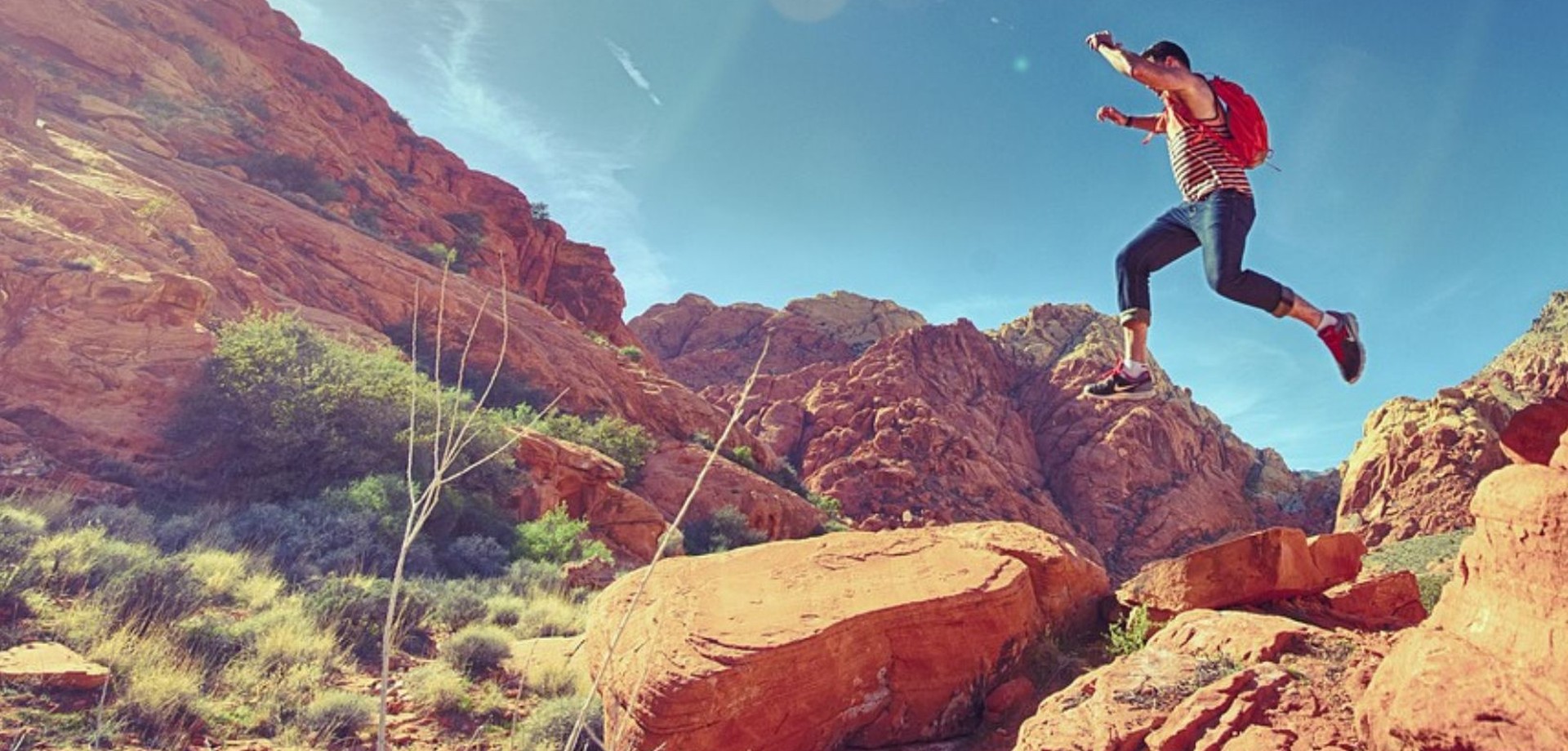 Eine Person die in einer Gebirgslandschaft den Sprung wagt. Foto: Jump_Bild von stokpic auf Pixabay